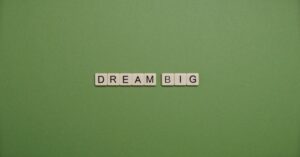 Inspiring 'Dream Big' message with tile letters on a simple green background.